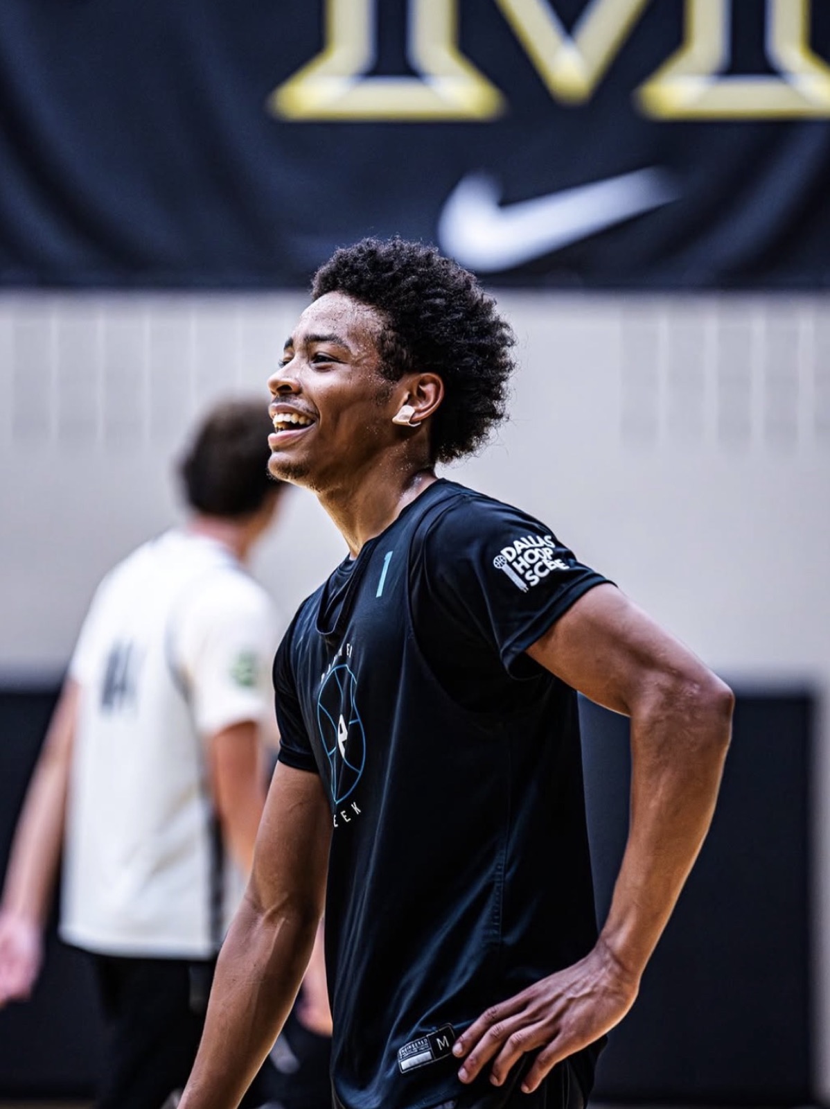 Player laughing under a Nike banner, the DHS logo sharp on the right sleeve